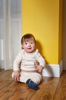 Cute little boy sitting on the floor in the living room