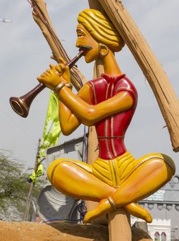 folk artist statue playing flute in the gate of surajkund fair