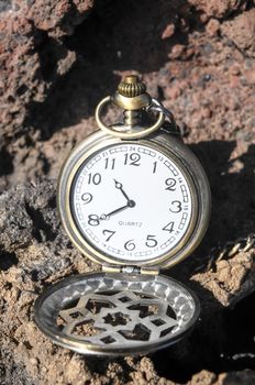 Time Concept Classic Vintage Pocket Clock on the Volcanic Rocks