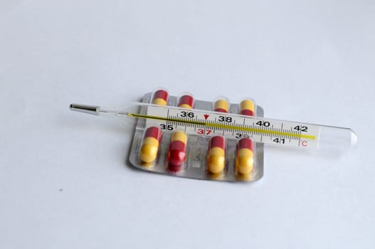 The increased temperature on a thermometer and pills