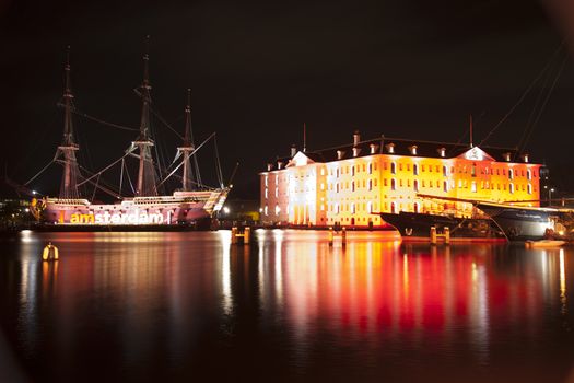 AMSTERDAM, THE NETHERLANDS: Building and ancient ship with lights at annual Amsterdam Light Festival on December 30, 2013. Amsterdam Light Festival is a winter light festival  