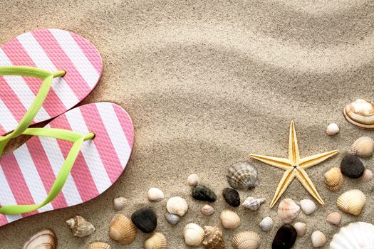 Sand background with flip flops and shells. Vacation concept. Top view