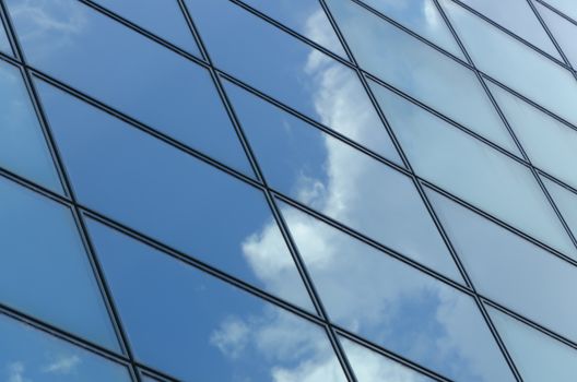 glass surface of a building with reflection of clouds and sky in it