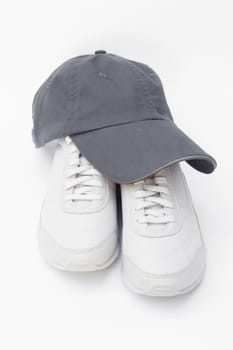 A pair of running shoes and a baseball cap