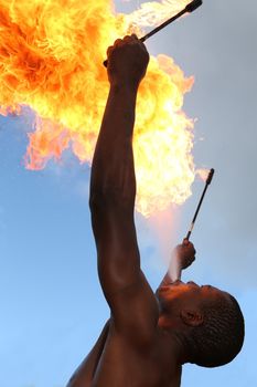 Circus fire-eater blowing a large flame from his mouth