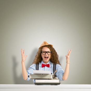 image of a young woman writer at the table with typewriter