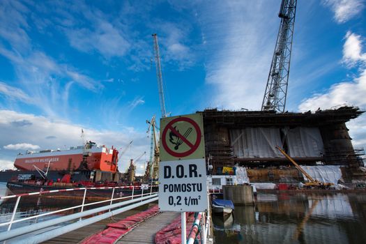 GDANSK, POLAND - SEPTEMBER 19: Docking oil rig at the Gdansk Shipyard under construction with a clear blue sky in the background. The oil rig weights 12 thousand tons. Gdansk, Poland, 2013