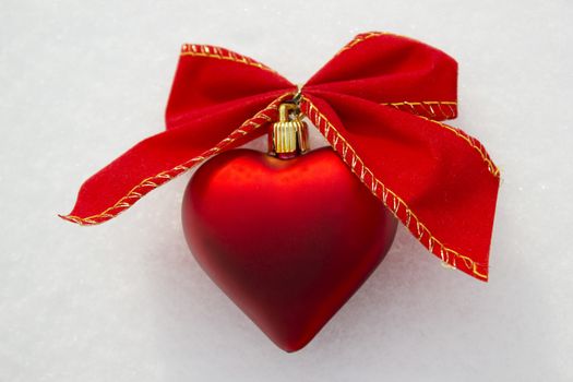 Heart shaped decoration with ribbons around it.