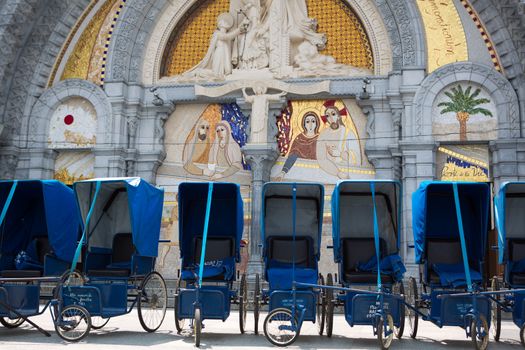 Loans of blue wheelchairs in front of the church within the Sanctuary in Lourdes, 2013. Every wheelchairs was a donation of a good fellow Christian. France 2013.