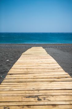 Traditional wooden walkway to the aegean sea. At a very peaceful beach of Crete, Greece, 2013.
