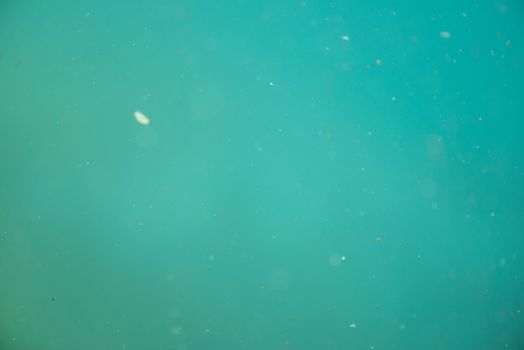 Green underwater pattern with dirt and dust as seen through glass