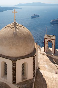 Passing cruise-boats on the aegean sea and Beautiful ornamented orthodox cross and dome.  There are many small churches all over Santorini.. and some larger churches in each of the major villages ..Greece, 2013.