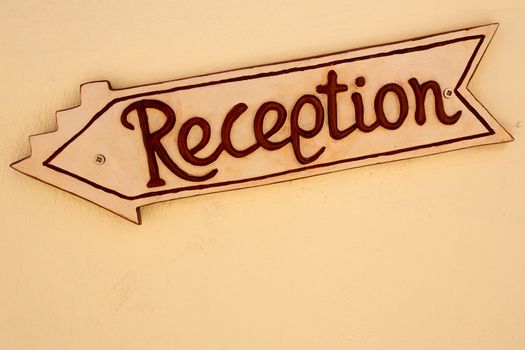 A yellow reception sign board in a hotel in Santorini, Greece