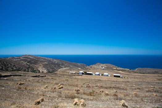 Panoramic view of the seashore of Folangandros, in the distance  are some traditional greek houses and a view of the peaceful aegean sea, Greece, 2013.