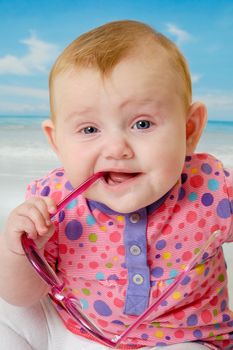 Sweet baby on vacation on beach with the sea in the background.