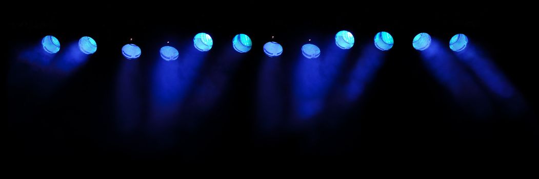 Lights and smoke. Row of blue lights from a stage.