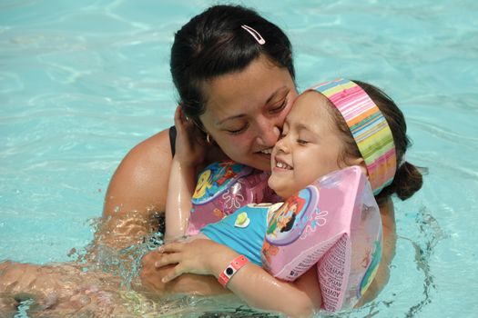 Happy woman and child is relaxing in pool