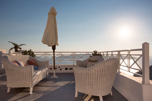 Santorini, a terrace and outdoors furniture with view of the Mediterranean sea in Greece.