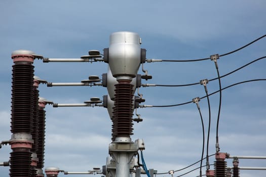 Detail view of a high-voltage electric pylon with a blue sky in the background