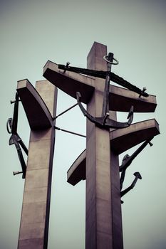 Gdansk monument to the fallen shipyard workers with a rainy weather in the background, toned image. Poland 2013.