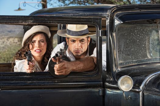 1920s vintage gangsters firing guns from car window