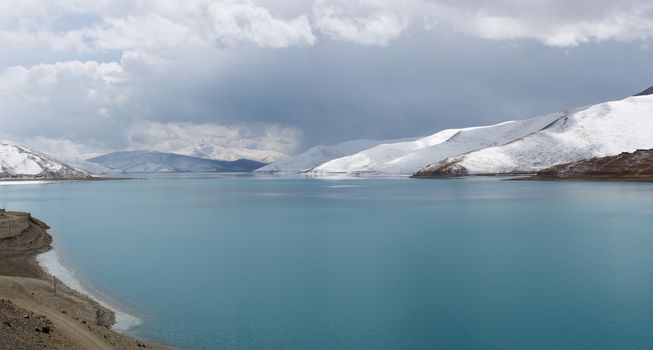 Detail of the Yamdrok lake on the Friendship road in Tibet with snow on the mountains