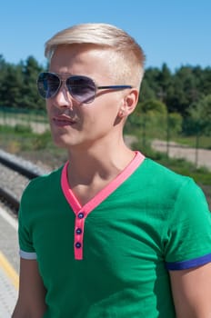 Shot of stylish man with sun glasses standing on platform