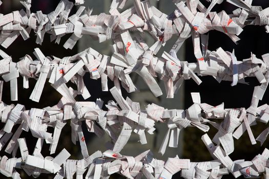 Dozens of omikuji, or fortunes, are wrapped on string at a Shinto temple in Takayama, Japan.