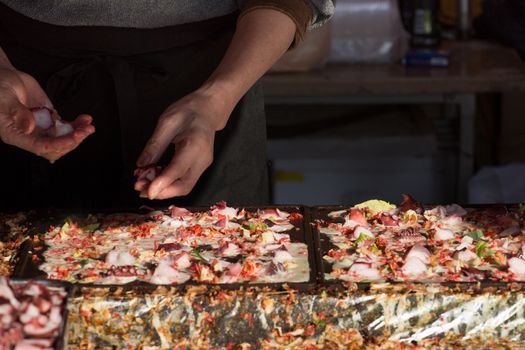 Japanese cook preparing fish with mixed vegetables. Shallow DOF and motion blur on the food.