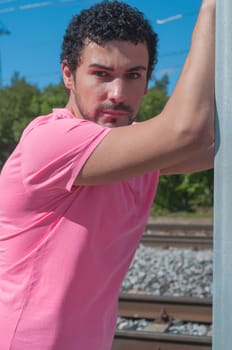 Handsome young man in pink t-shirt watching on you