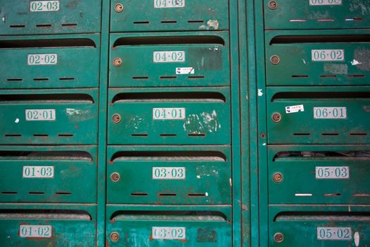 Pattern of old and unidentified green mailbox in an old residential building in Shanghai. Each number represents the floor and the flat number. China, 2013.