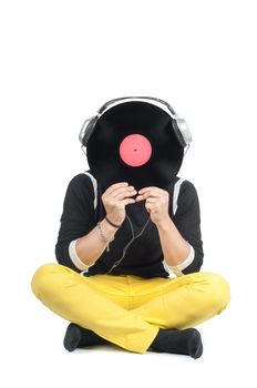 Man hiding his face with vinyl record sitting on the floor
