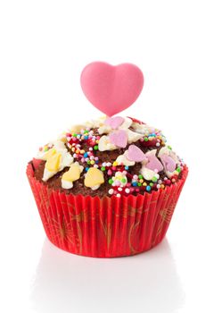 Cupcake with heart candy on top, isolated on white