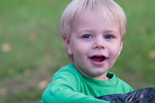 Happy smiling baby boy in green top