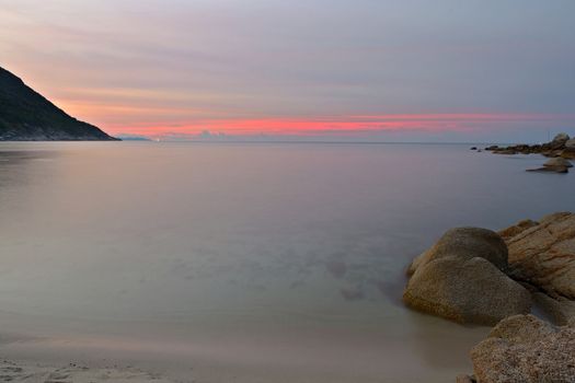 Vibrant colored sunset and blurred motion seascape at Ao Haad Khaud, Koh Phangan, Southern Thailand.