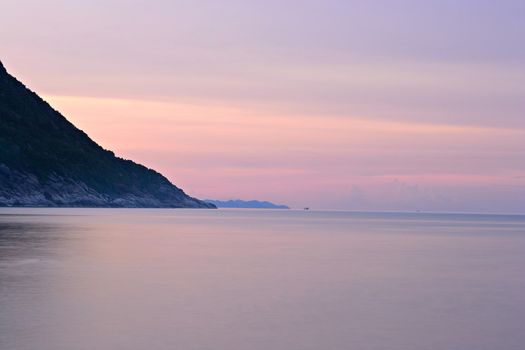 Vibrant colored sunset and blurred motion seascape at Ao Haad Khaud, Koh Phangan, Southern Thailand.