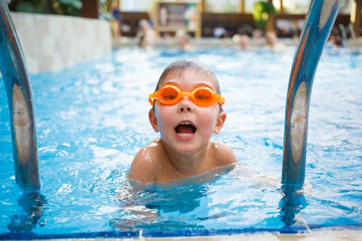 Activities on the pool. Cute boy in swimming pool