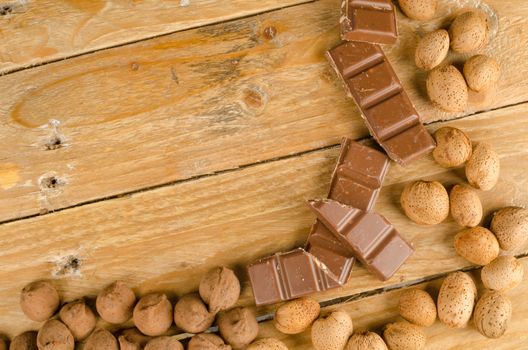 Nuts and chcolate displayed on a rustic wooden background