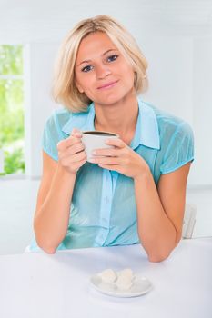 beautiful caucasian female sitting at table and drinking coffee