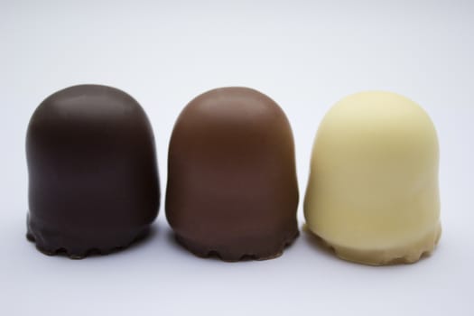 Chocolate covered dark brown, light brown and white marshmallows.