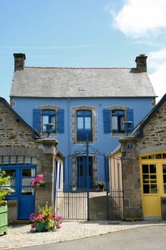 Facade of traditional breton houses with blue shutters, france