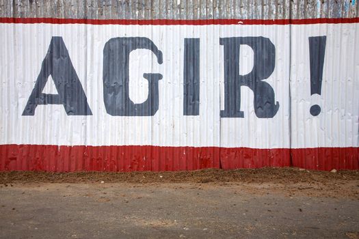 Message on a wall in Saint Louis with urgent action word. Senegal 2010.