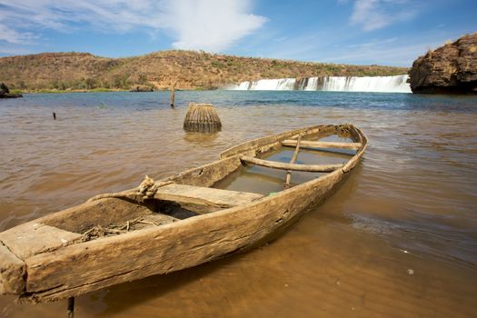 Broken small boat in the River Senegal near Kayes in Mali with the waterfalls in the background