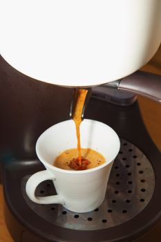 Coffee machine pouring coffee in a white cup