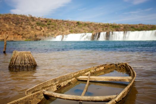 Broken small boat in the River Senegal near Kayes in Mali with the waterfalls in the background