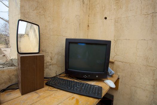 Old computer and a mirror in the office zone, every device is connected and working, no internet available.