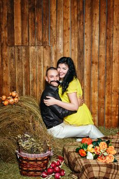 Young attractive couple playfully embrace in the hayloft in the village