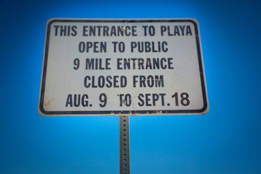 Road sign against a blue sky at the entrance of la Playa in the Black Rock desert in the state of Nevada, location of a famous alternative festival only accessible from August 9 to September 18 only.