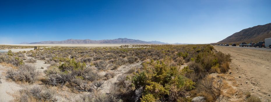 Panoramic view of the traffic on the road and the Black Rock Desert in Nevada. All the cars are leaving the site of the Burning Man Festival edition 2012 in Nevada, United States.