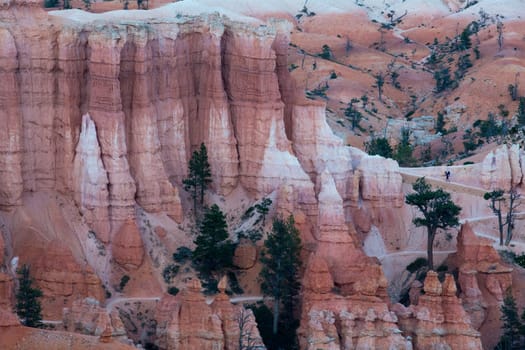 View to one of the amphitheatres of Bryce Canyon late afternoon with a man climbing it